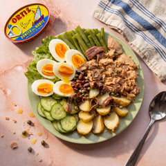 Niçoise salad with Ortiz tuna, eggs and potatoes beside the open tin