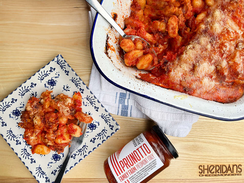 Baked gnocchi al forno in a dish with a jar of Prunotto tomatoes