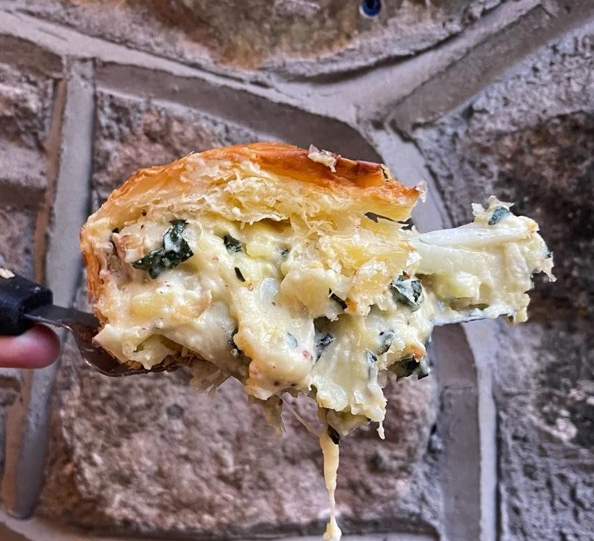 Slice of potato and cheese pie being lifted, with melting cheese
