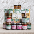 Collection of Sheridans food products including jars and boxes on a textured surface with a white background.