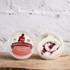 Two containers of Ardsallagh Cranberry Roulade on a wooden surface with a white textured background