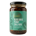 Jar of black garlic peanut chilli rayu with green label on a white background