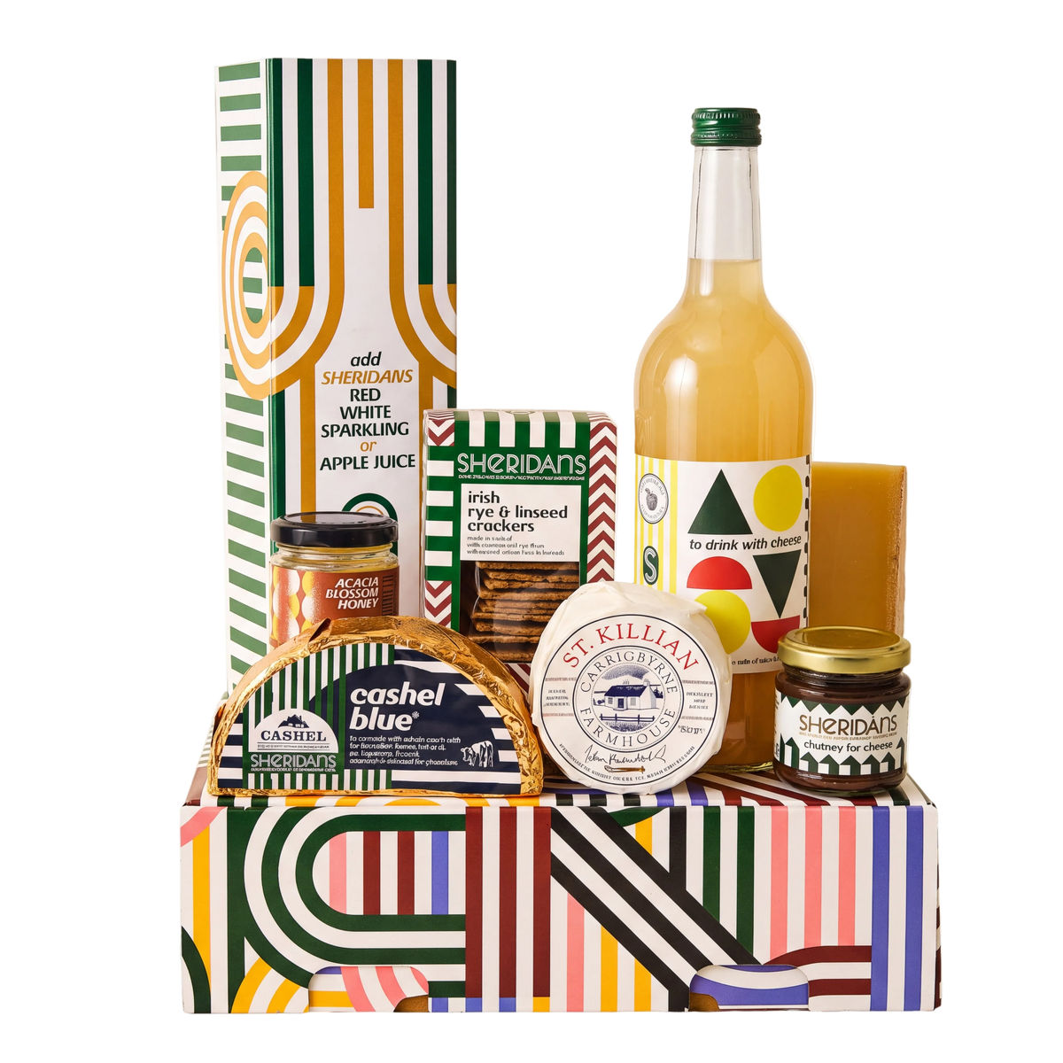 A curated gift hamper set in a colorful striped box, featuring a bottle of apple juice, jars of spreads, crackers, and a decorative box, photographed on a clean white background.