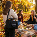 People enjoying a picnic in an autumn park with a Sherpa brand bag.