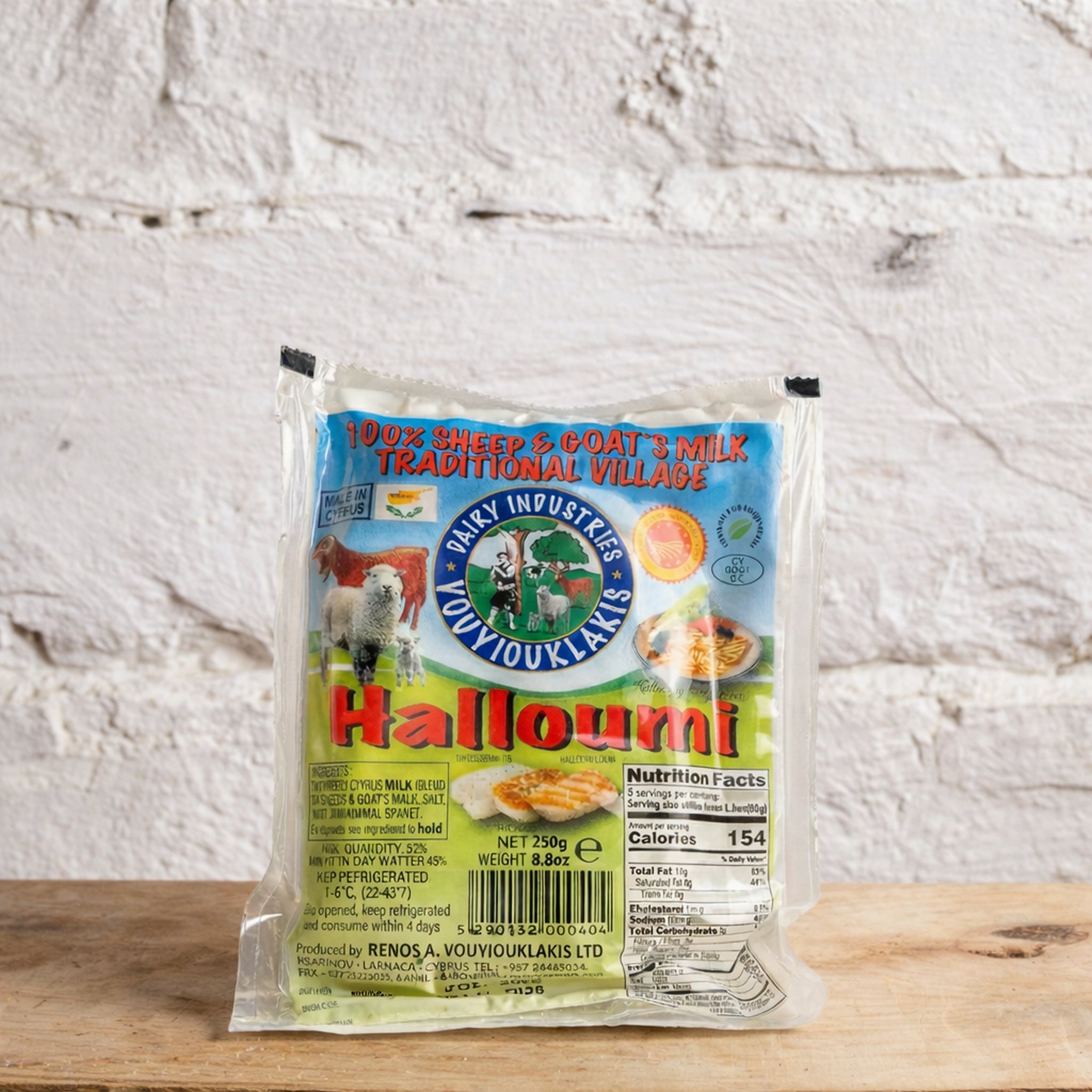 Packaged halloumi cheese with a brand label on a wooden surface and light gray background