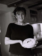 Black and white photo of a woman holding a round object with branding.