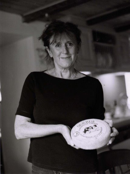 Black and white photo of a woman holding a round object with branding.