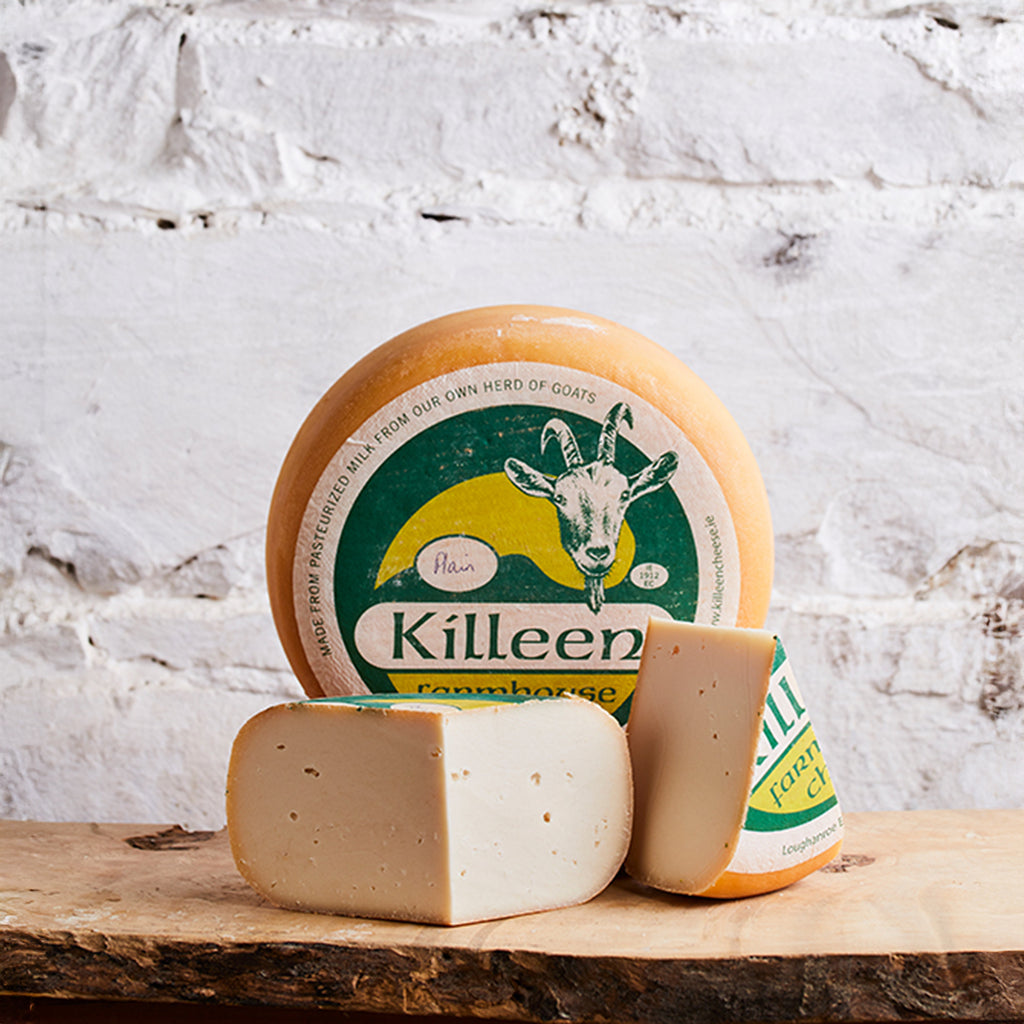 Killeen Farmhouse cheese on a wooden board with a white marble background