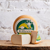 Killeen Farmhouse cheese on a wooden board with a white marble background