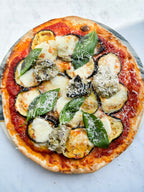 Vegetable pizza with zucchini, aubergine, and cheese on a metal tray.