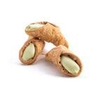 Three cannoli shells filled with a green cream on a white background
