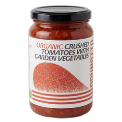 Jar of organic crushed tomatoes with garden vegetables on a white background