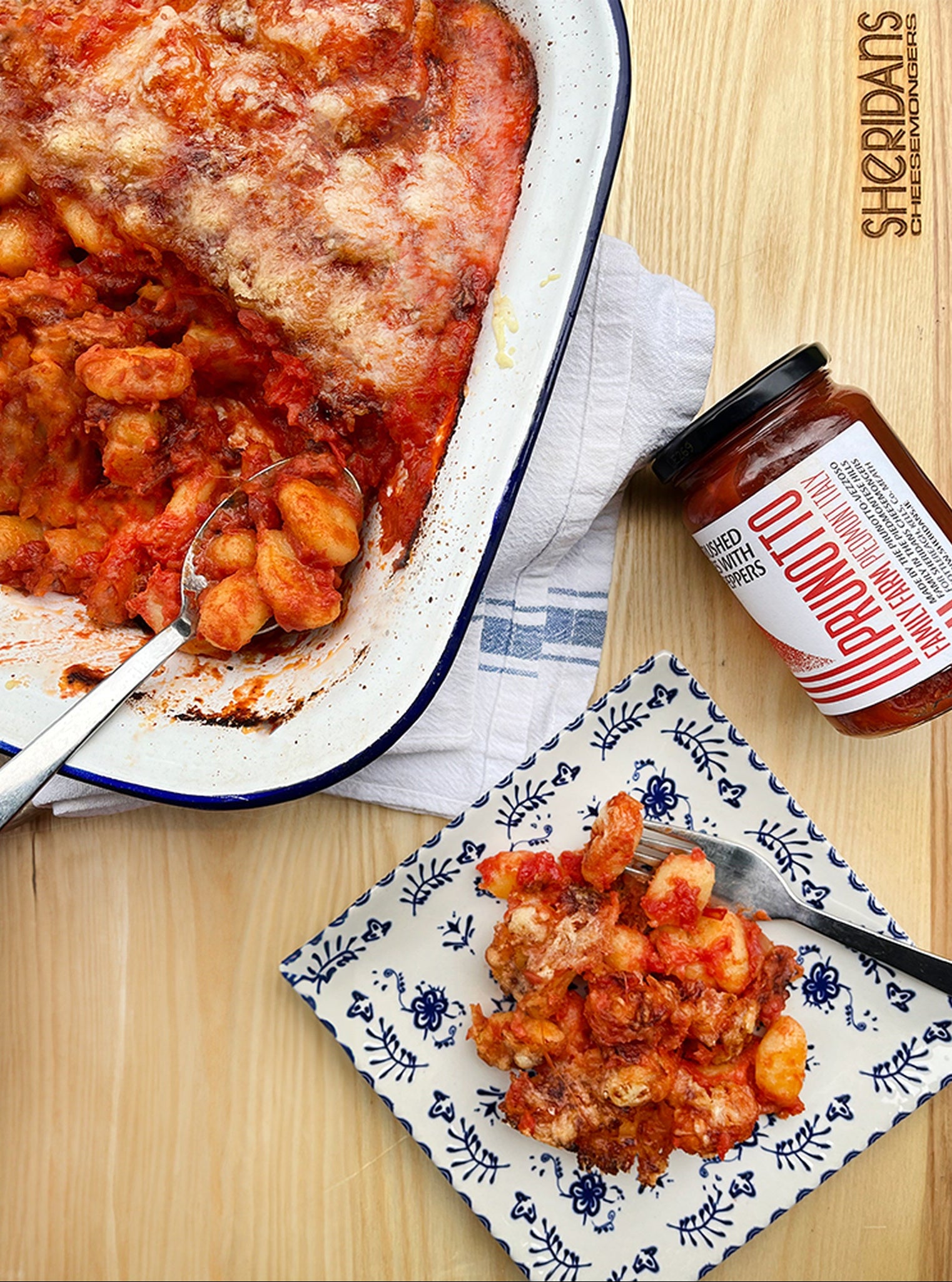 Gnocchi dish with a jar of sauce on a wooden table