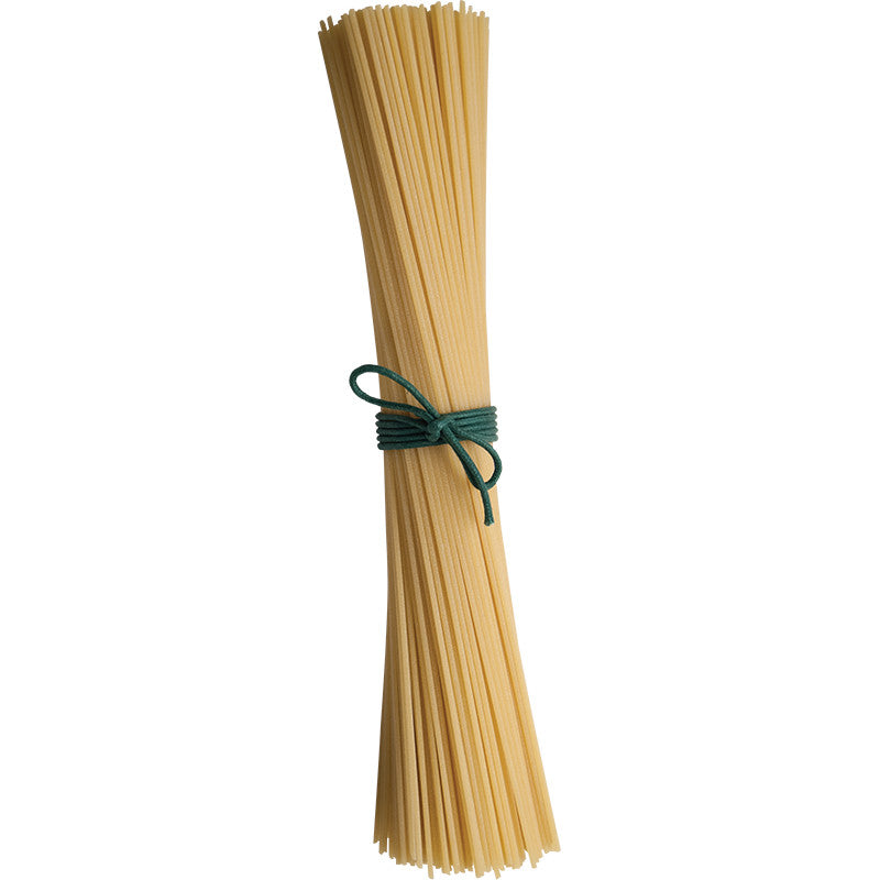 Bundle of uncooked spaghetti noodles tied with a green rubber band on a white background