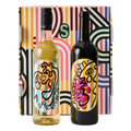 Two wine bottles with colorful labels in front of a patterned box.
