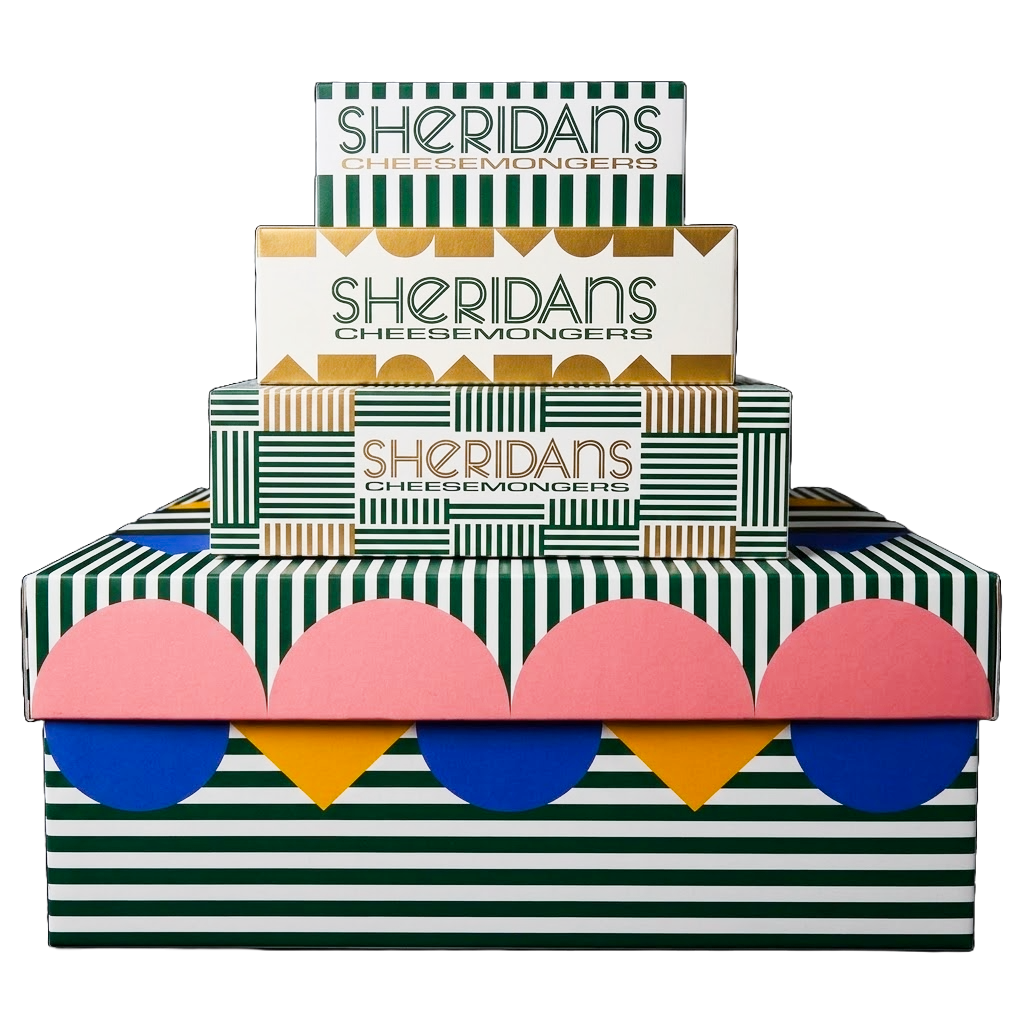 Three stacked boxes of Sheridan's Cheeseemongers with a colorful retro design featuring green and white stripes, pink, blue, and yellow scalloped patterns, and gold accents.