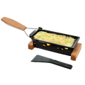 Black raclette grill with wooden handle and spatula on a white background