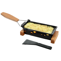 Black raclette grill with wooden handle and spatula on a white background