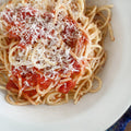 Plate of spaghetti with tomato sauce and grated parmesan